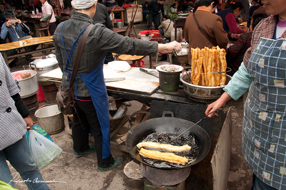 Frittura nel wok nella zona dei chioschi di cibo di un mercato