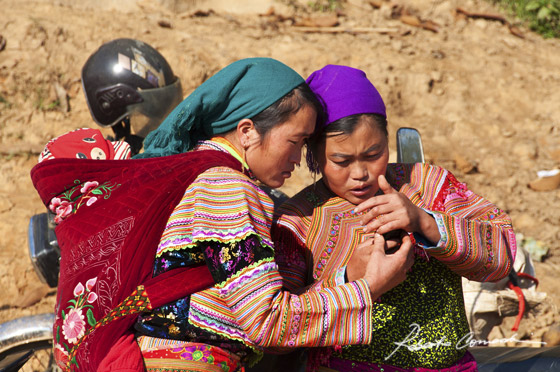 Due donne Hmong Floreali controllano il cellulare al mercato di Can Cau