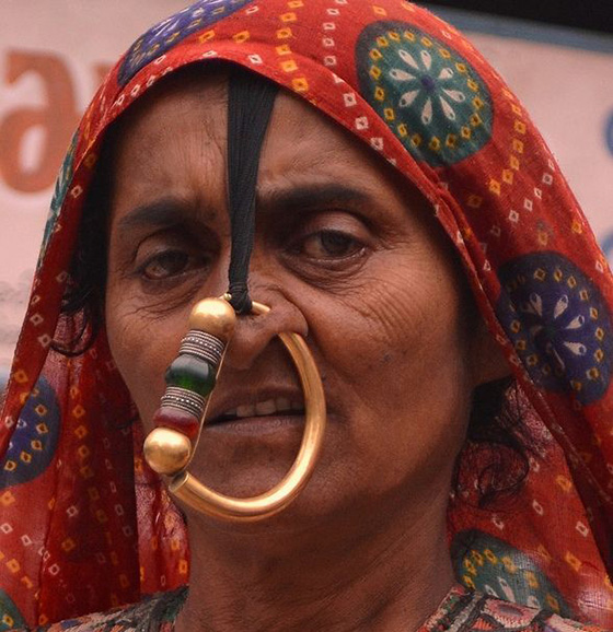 Donna Kutchi (India) con pesante piercing che trafora il naso, al punto che viene legato ad una ciocca di capelli