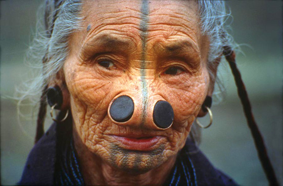Le donne Apa Tani (India) applicano dei dischi di legno sulle narici.