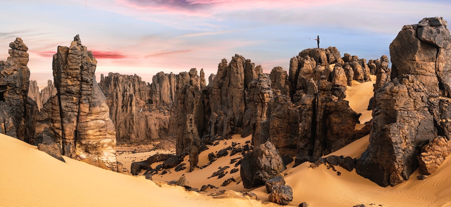 deserto con rocce e tuareg in cima